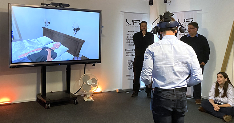 En man med VR-utrustning tittar på en skärm med en datoranimerad figur.