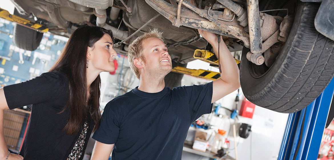 En kvinna och en man i en bilverkstad.