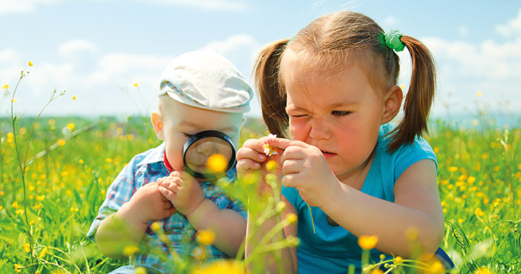 En flicka och en pojke som studerar blommor.