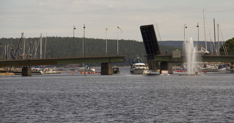 en båt på väg mot en bro som är öppnad