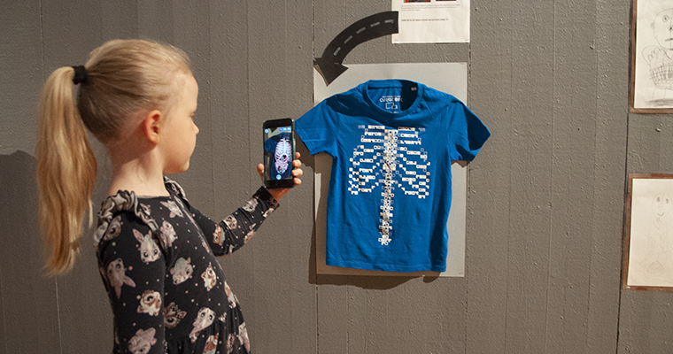 Junie Jernberg scannar koden på en t-shirt och kan då
se hur magen ser ut inuti.