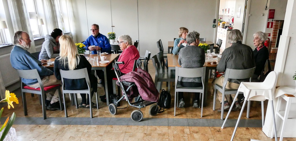 En grupp människor som sitter runt ett träbord.