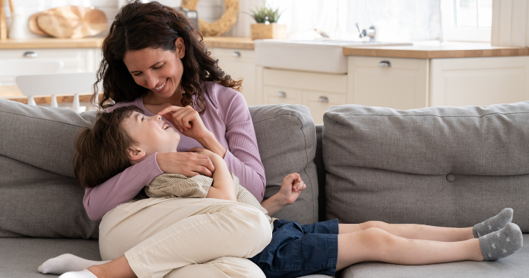 kvinna med barn i knä i soffan