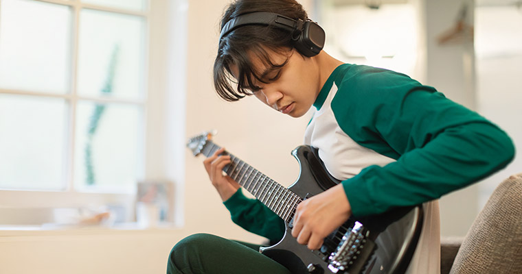 En kille som spelar elgitarr.