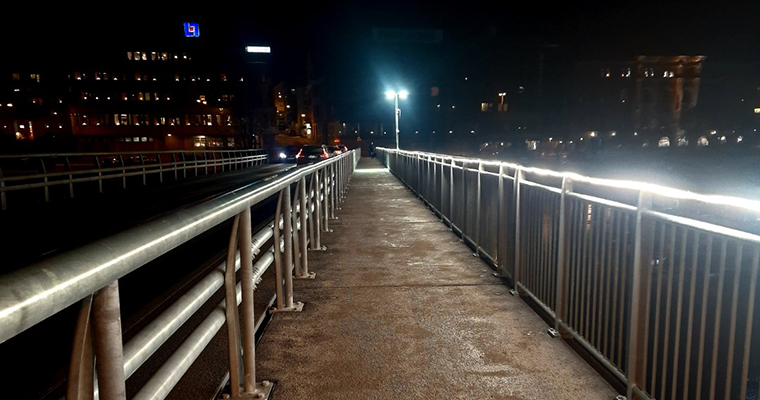 tillfälliga bron i mörker med belysning längs broräcket