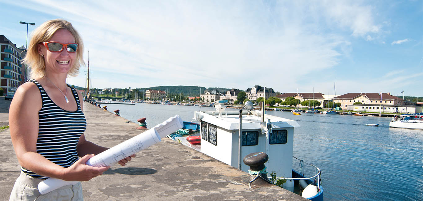 Kvinna med ritningar vid hamnen i Härnösand