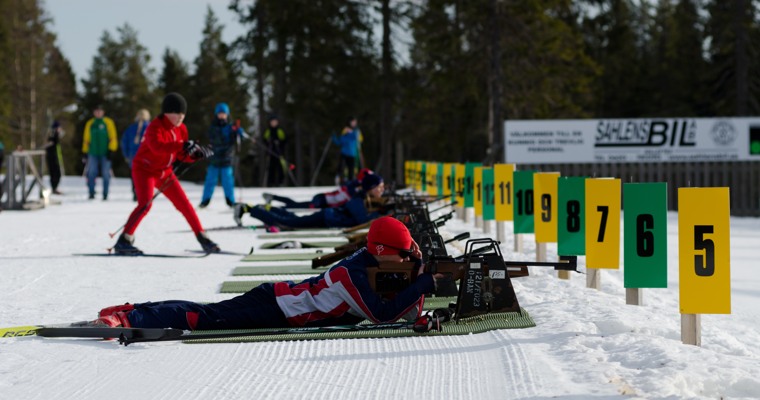 flera skidskyttar ligger och skjuter på en skjutvall
