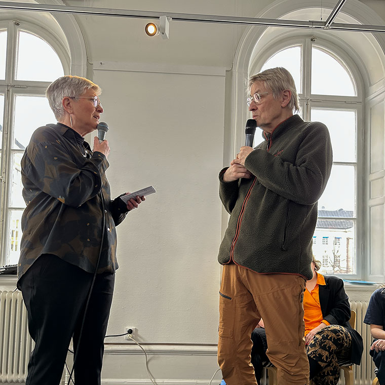 en kvinna och en man på en scen med varsin mikrofon