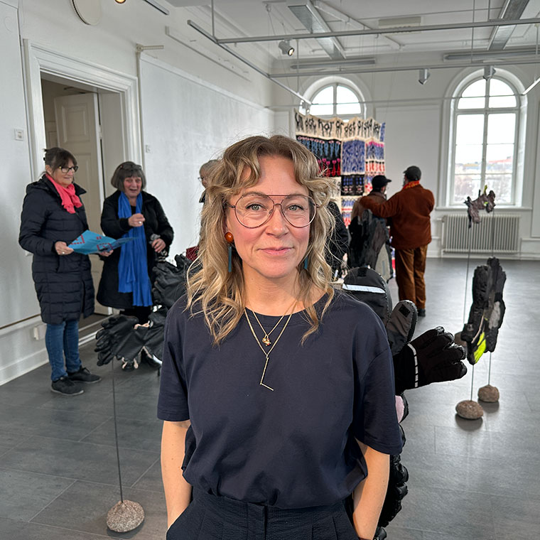 en kvinna står i ett rum i en konsthall