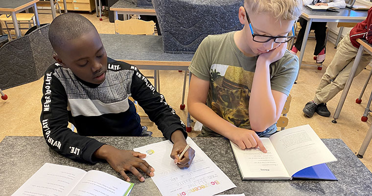 Modest och Simon läser och skriver recensioner i 4A:s klassrum under ReadHour.