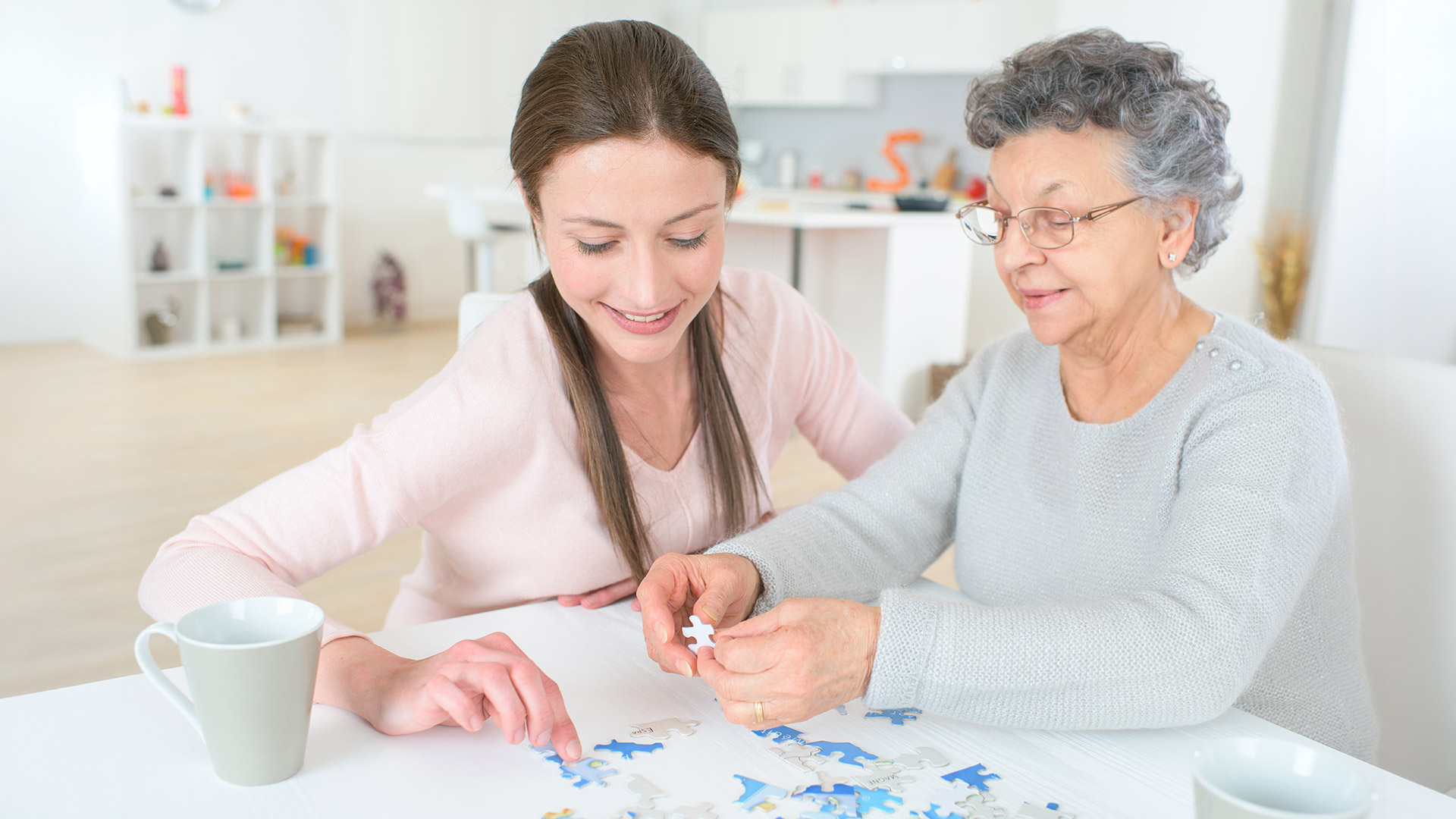 En ung flicka och en äldre kvinna lägger pussel