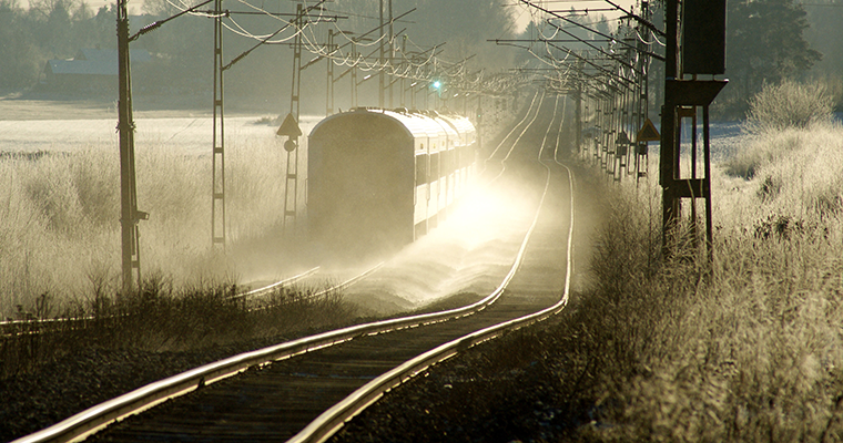 tåg som rullar på rak järnväg i lite dovt ljus