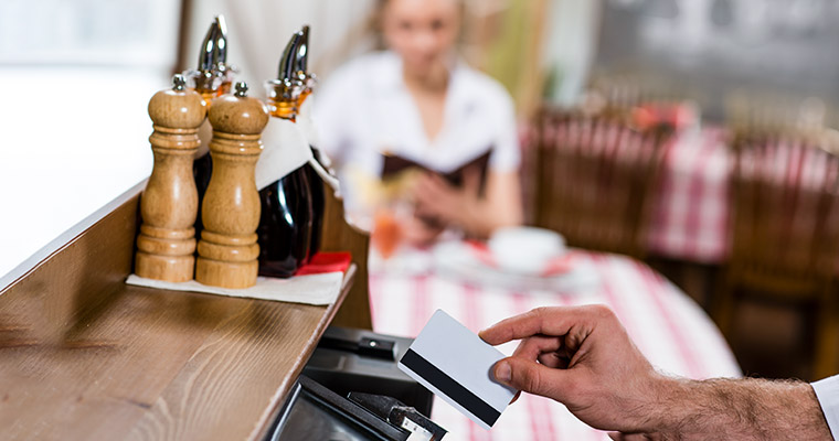 En man tar betalt i en restaurang.