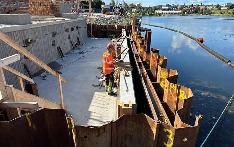 en person i arbetskläder arbetar på ett brobygge