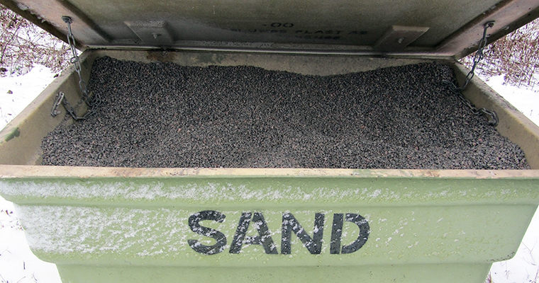 en stor grön låda med öppet lock som är fylld med sand. På lådan står det "sand"