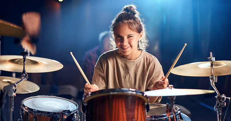 En flicka som spelar trummor.