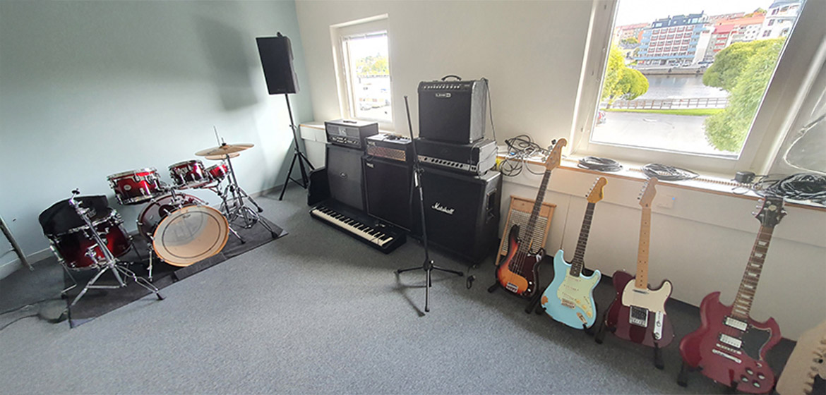 rum med trummor, förstärkare och flera gitarrer
