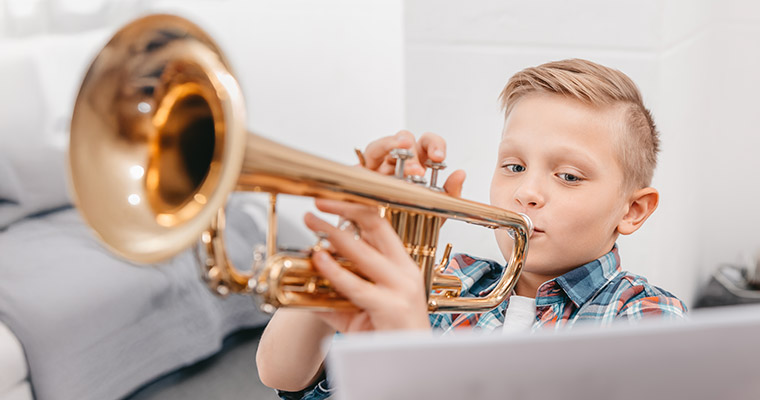 En pojke som spelar trumpet.