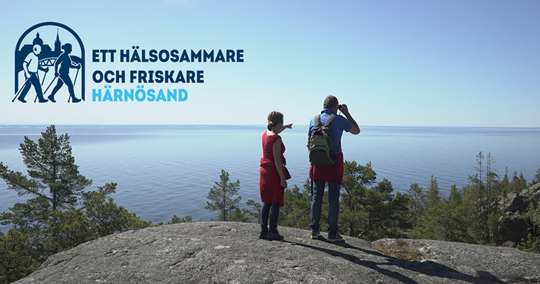 Ett äldre par står på ett berg och tittar ut över havet.