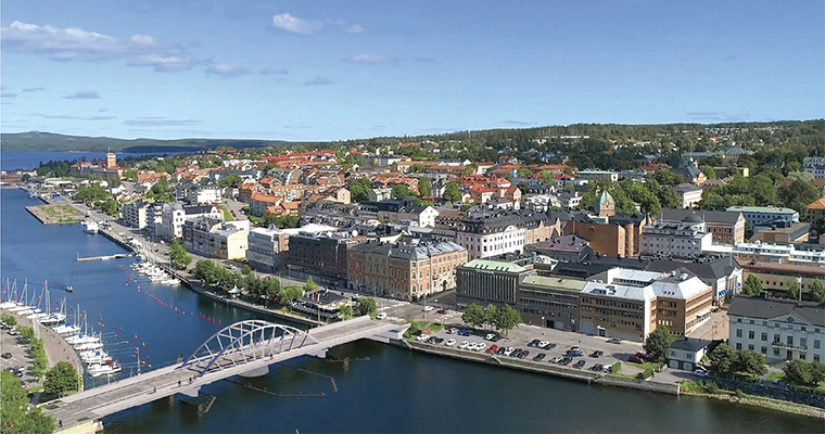 flygbild över en stad med en bågbro inmonterad över ett sund