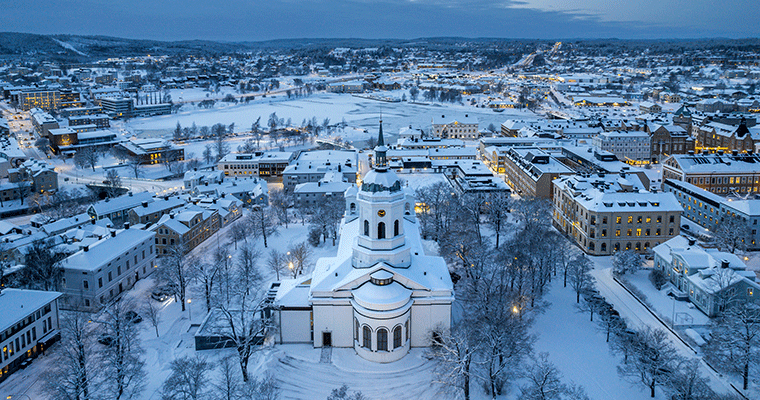 Flygbild över Härnösand i vinterskrud med domkyrkan i fokus.