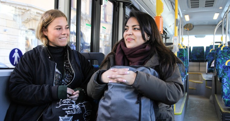 två kvinnor sitter tillsammans i en buss