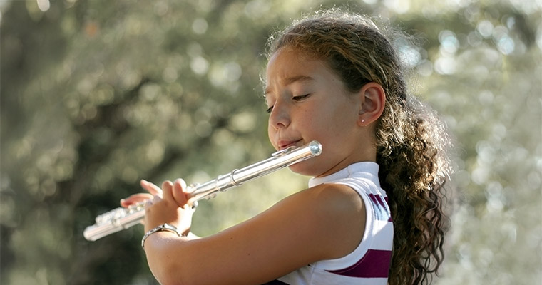 En flicka som spelar tvärflöjt.