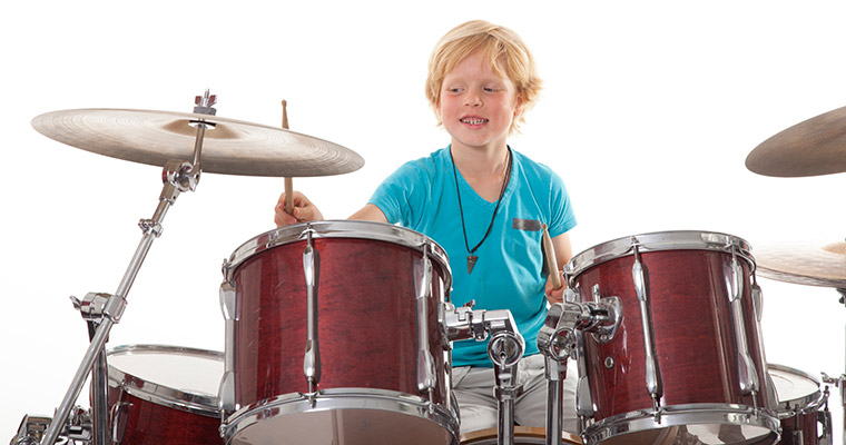 En pojke som spelar trummor.