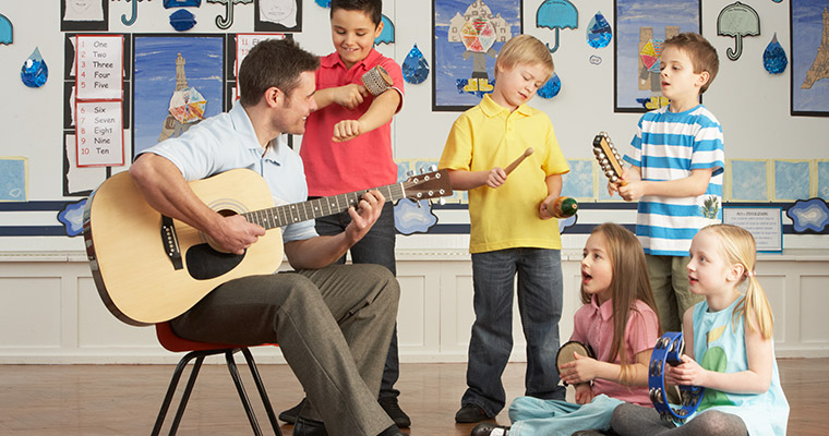 Barn och en lärare spelar musik.