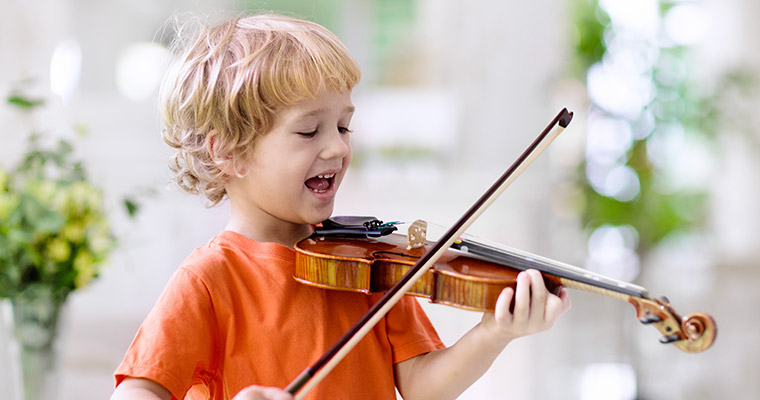 En pojke som spelar fiol.