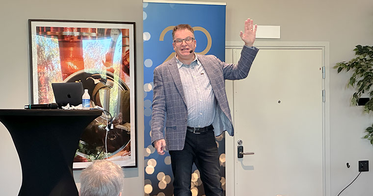 en man står på en scen med ena handen uppsträckt i luften