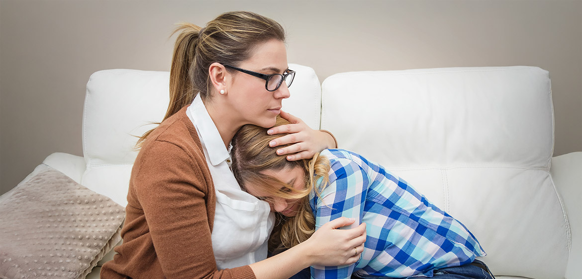 En mamma som tröstar sin dotter.