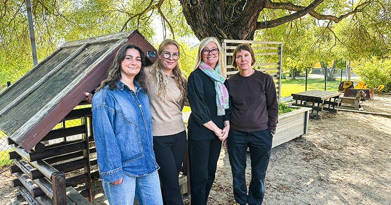 Fyra kvinnor står under ett träd