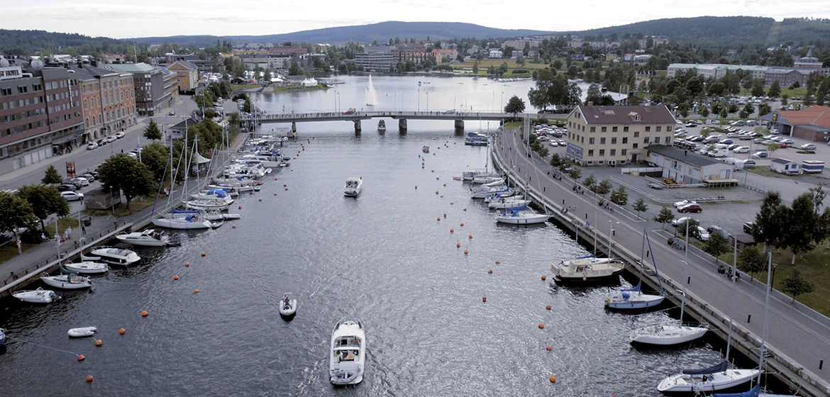 bild över ett sund genom en stad. båtar åker på vattnet och ligger längs kajerna. I bakgrunden finns en bro över vattnet