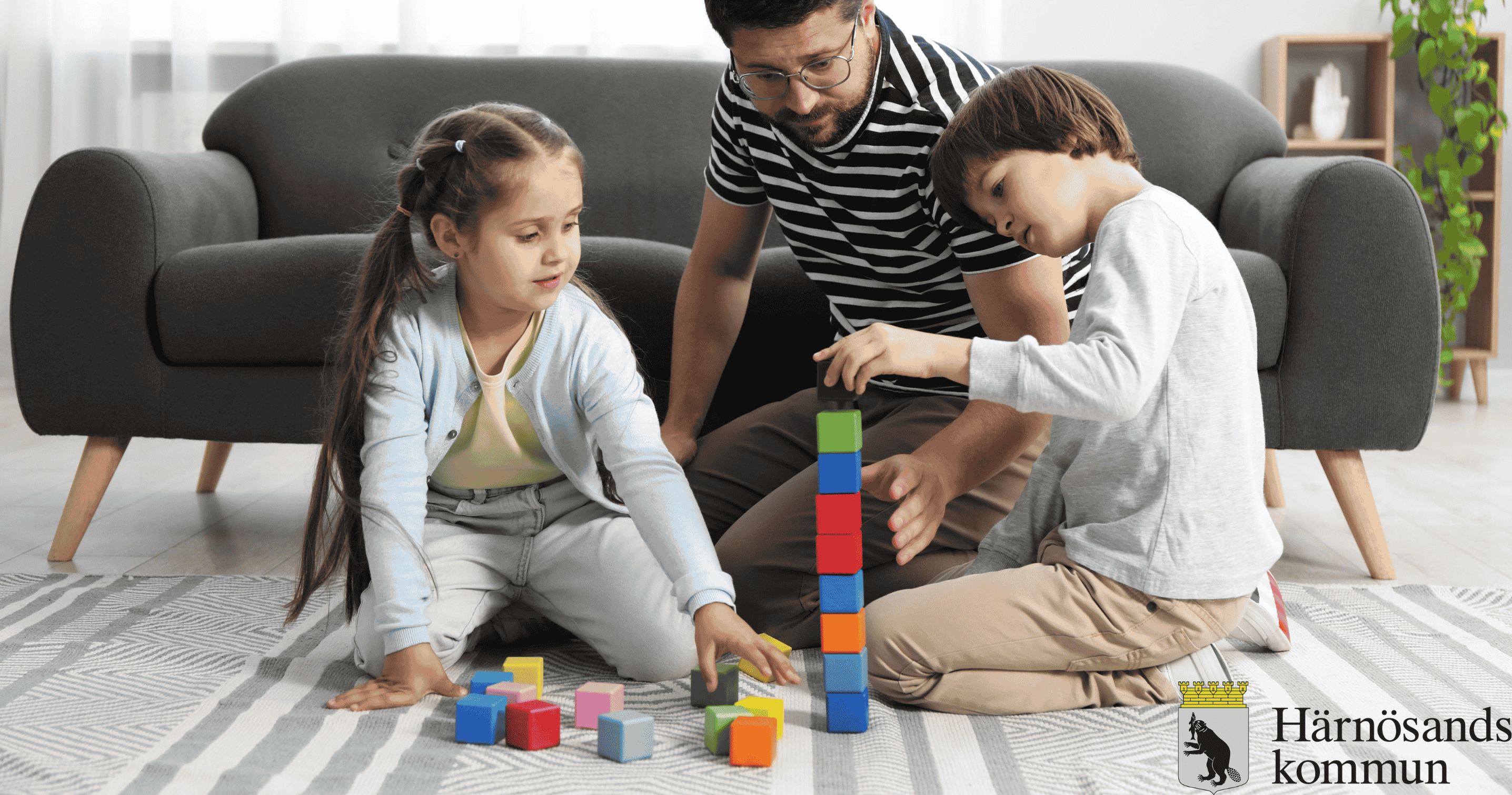 Barnen och pappan leker
med klossar   