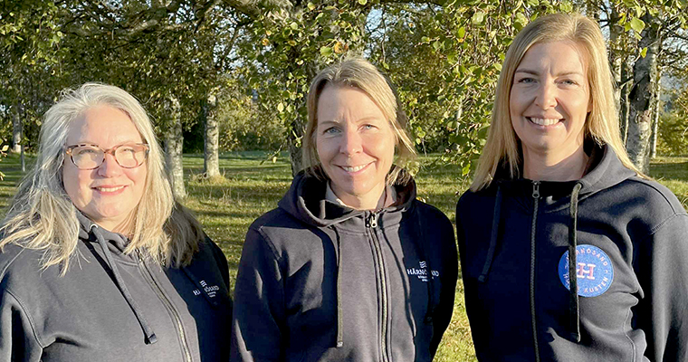 Tre leende kvinnor med profilkläder med texten "Härnösand".