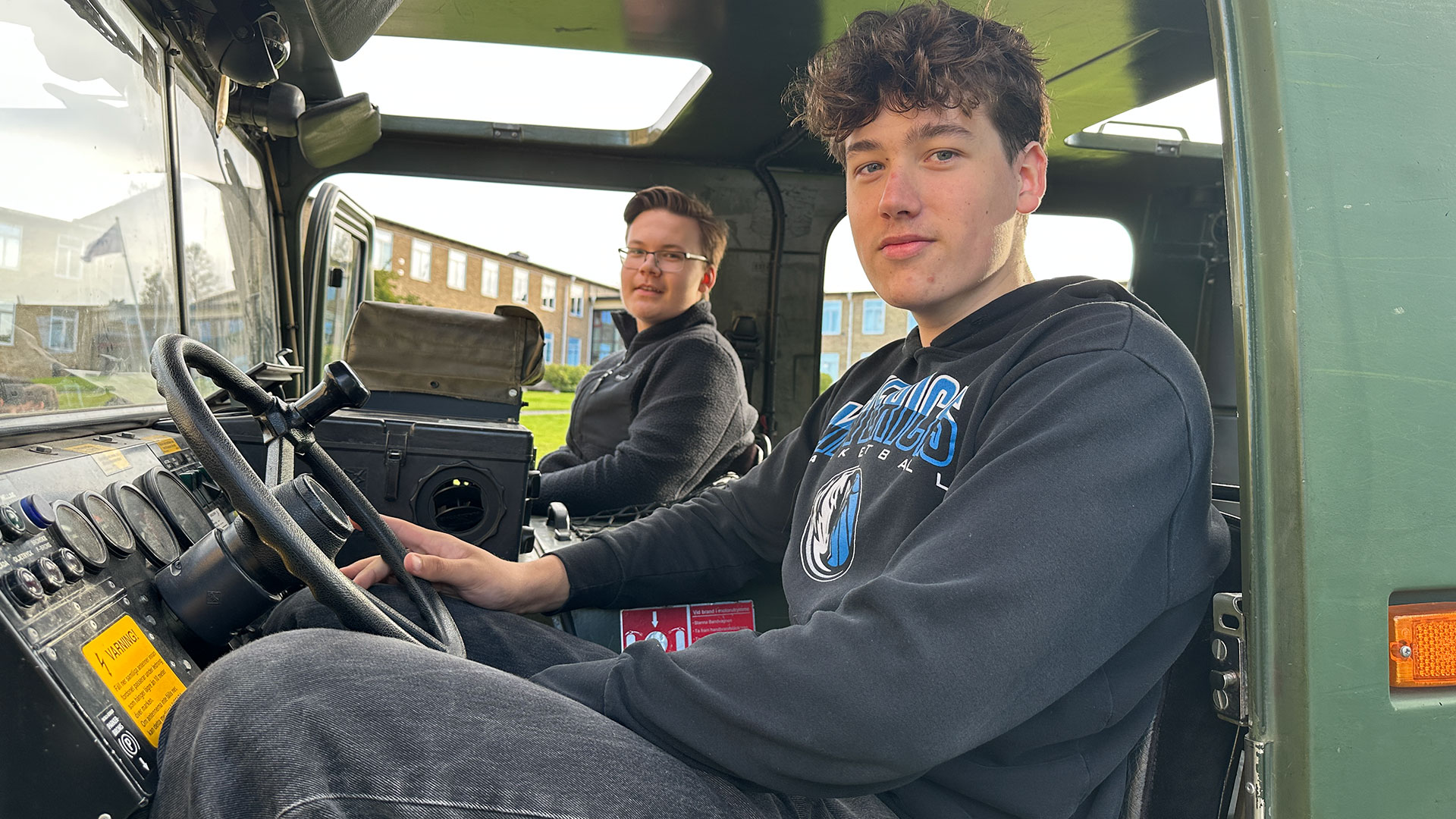 två unga män sitter i en bandvagn