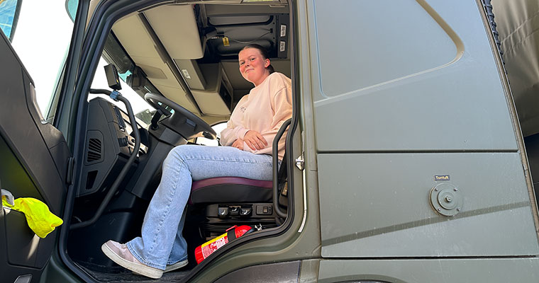 En ung kvinna sitter i en lastbilshytt