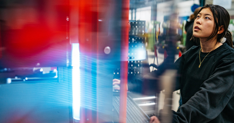 Kvinnlig tekniker vid en dator