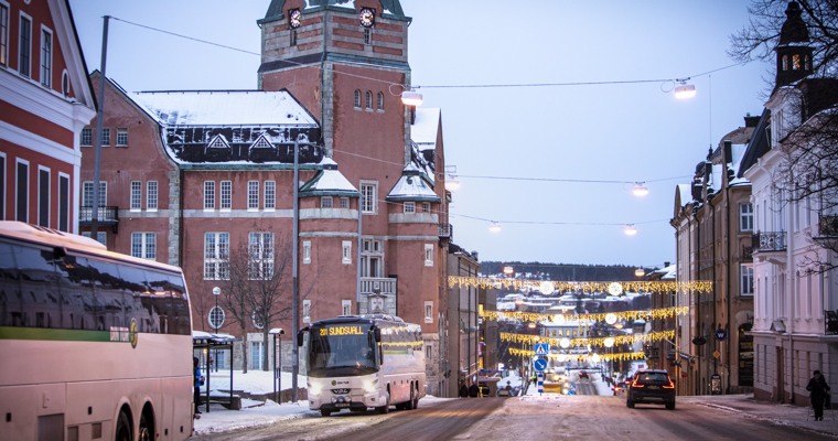 bussar som står vid en hållplats på en stor gata