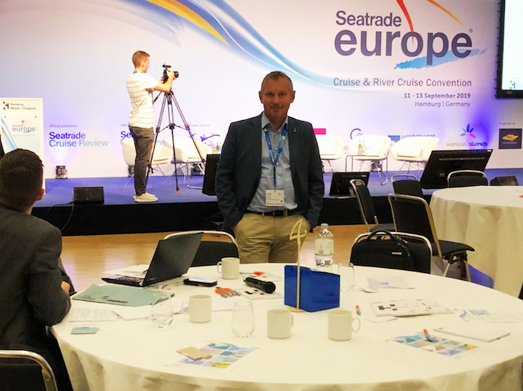 Man står vid runt konferensbord i bakgrunden scen med vepa där det står Seatrade Europe.
