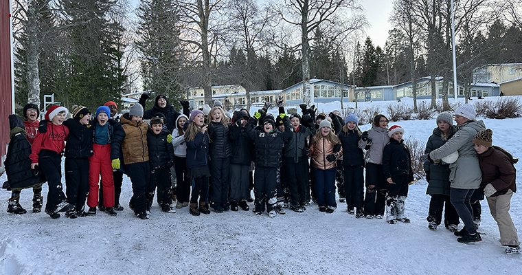 en stor grupp barn står på en skolgård