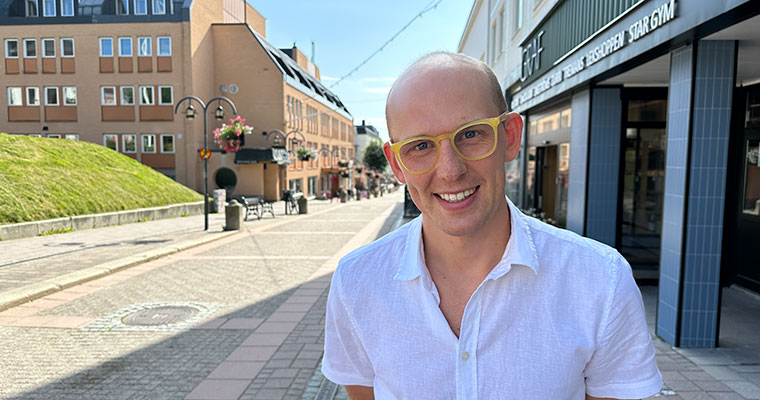 Porträtt på en man som står på en gågata