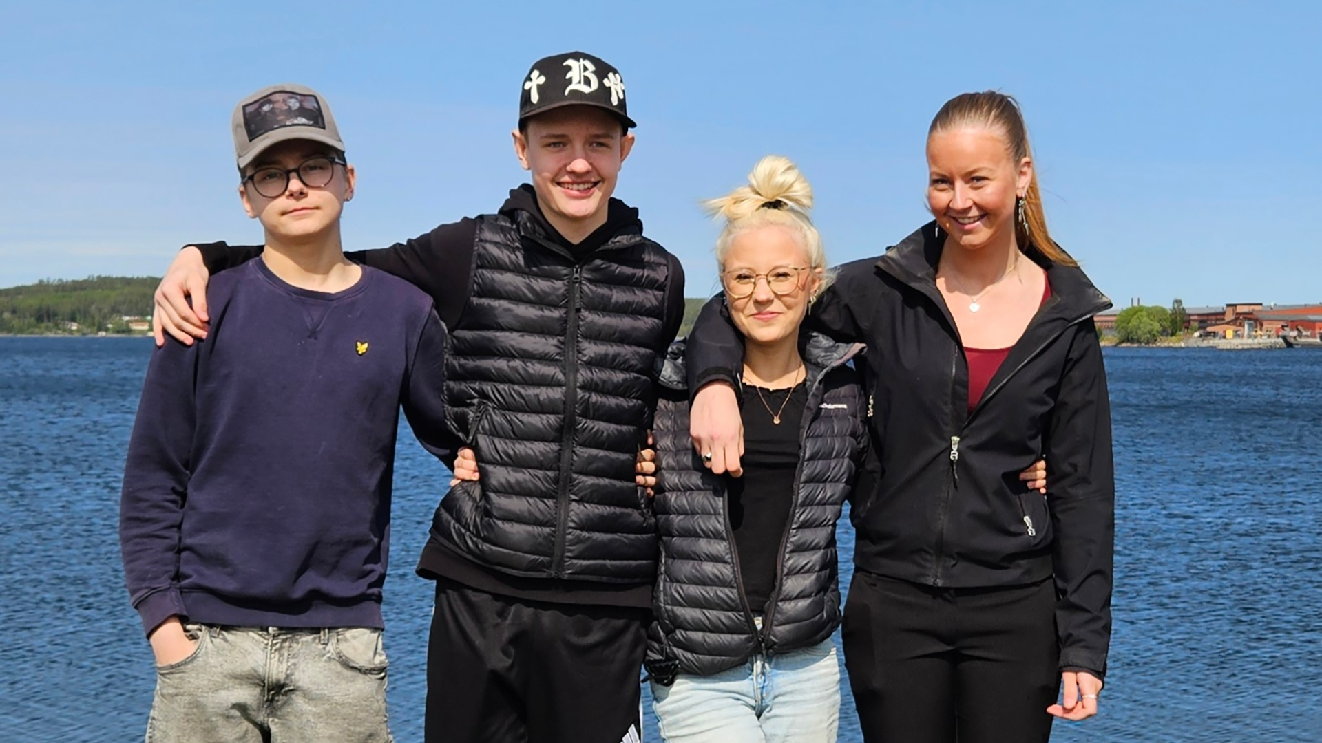 Fyra ungdomar på rad med armarna omkring varandra