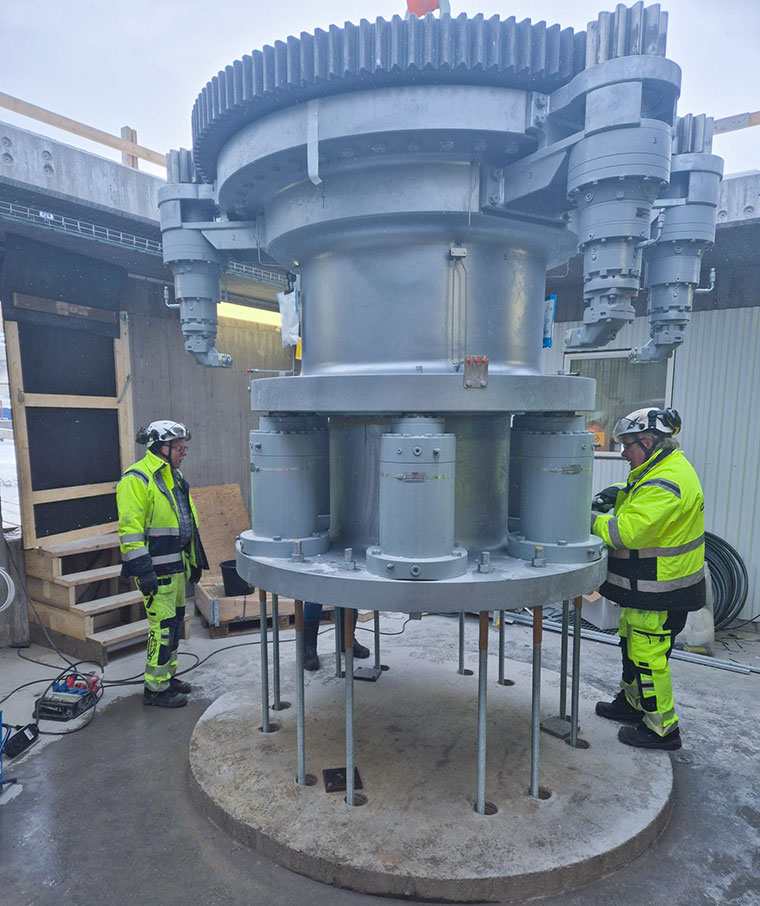 två män i arbetskläder står vid en stor maskin