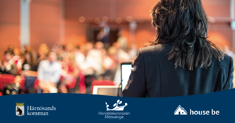 En kvinna står och föreläser för en publik