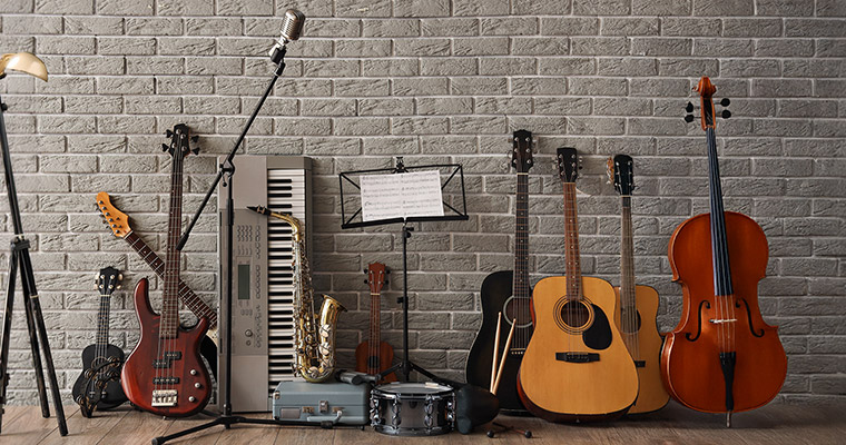 Flera olika musikinstrument står mot en vägg.
