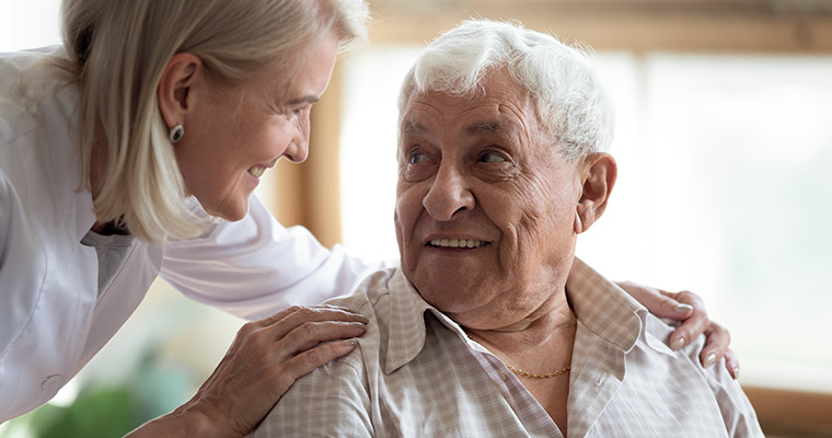 En kvinna som hjälper en äldre man.