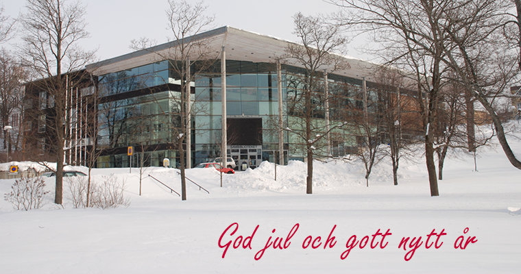 En bild på ett snöigt Sambiblioteket med texten god jul och gott nytt år.