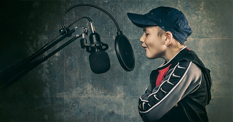 Pojke med keps sjunger i mikrofon